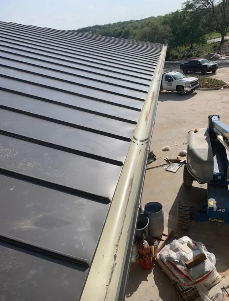Standing seam panel and gutter detail on a metal roofing jobsite in Burkburnett